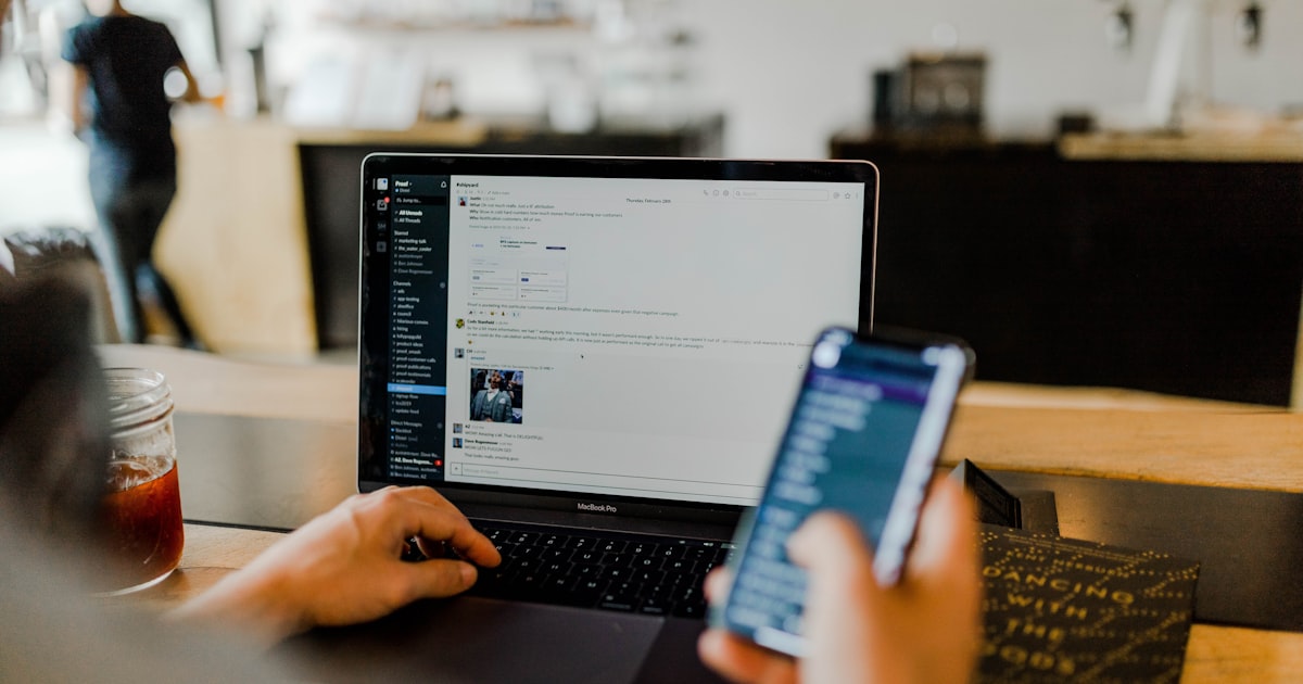 Person checking email on a laptop and phone