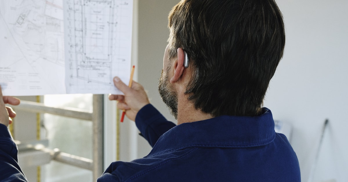 Builder reviewing construction plans on site