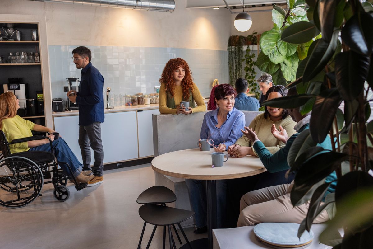 Diverse team socialising in office breakroom